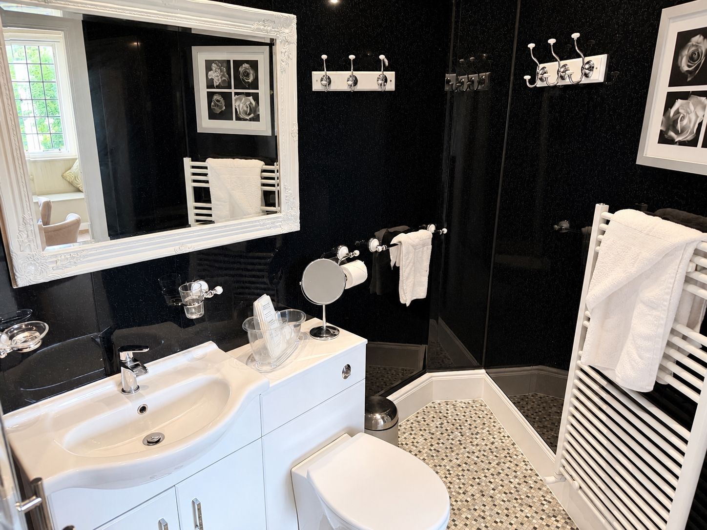 Un baño moderno con un espejo grande, dos lavamanos, un inodoro y una zona de ducha.