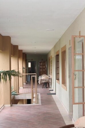 A corridor with a dining area, a staircase, and a door with a glass panel. - Batter Boys Boutique Hotel (Pretoria)