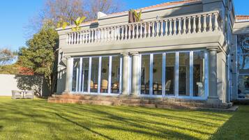 A building with a covered patio area, columns, and a clear sky.