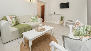 Family Suite | Living area | 24-inch flat-screen TV with satellite channels, TV