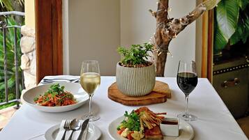 A dining table with plates of food, glasses of wine, and cutlery.