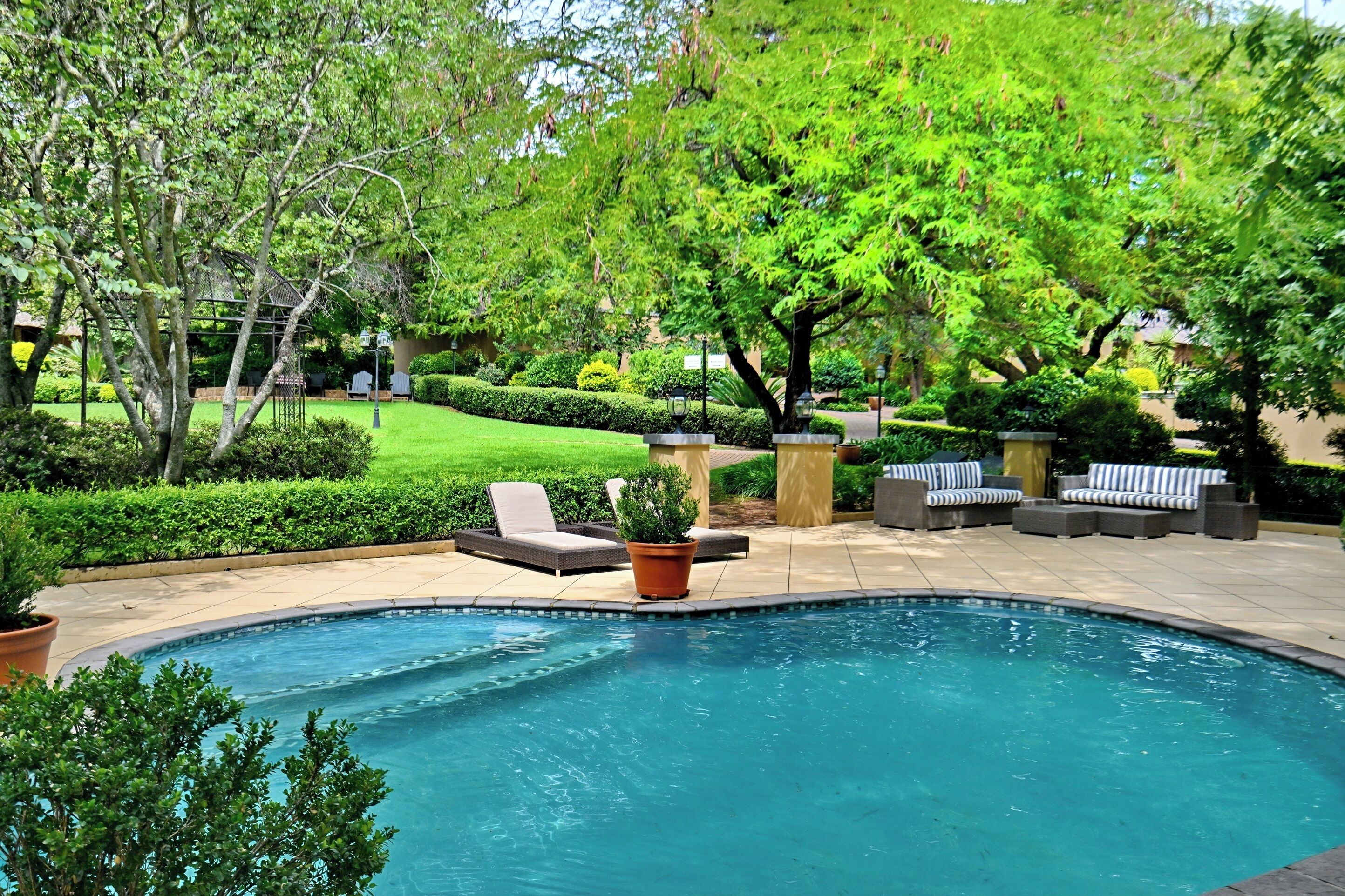 Una piscina al aire libre, sombrillas, tumbonas