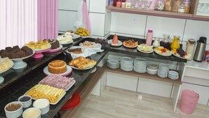 A buffet with various food items and condiments. - Pousada Rosa (Penha)