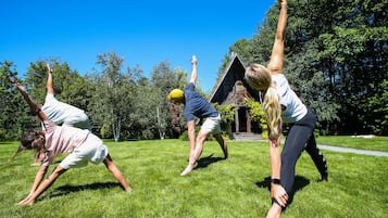 Guests can enjoy outdoor activities on the lush lawn surrounded by trees.