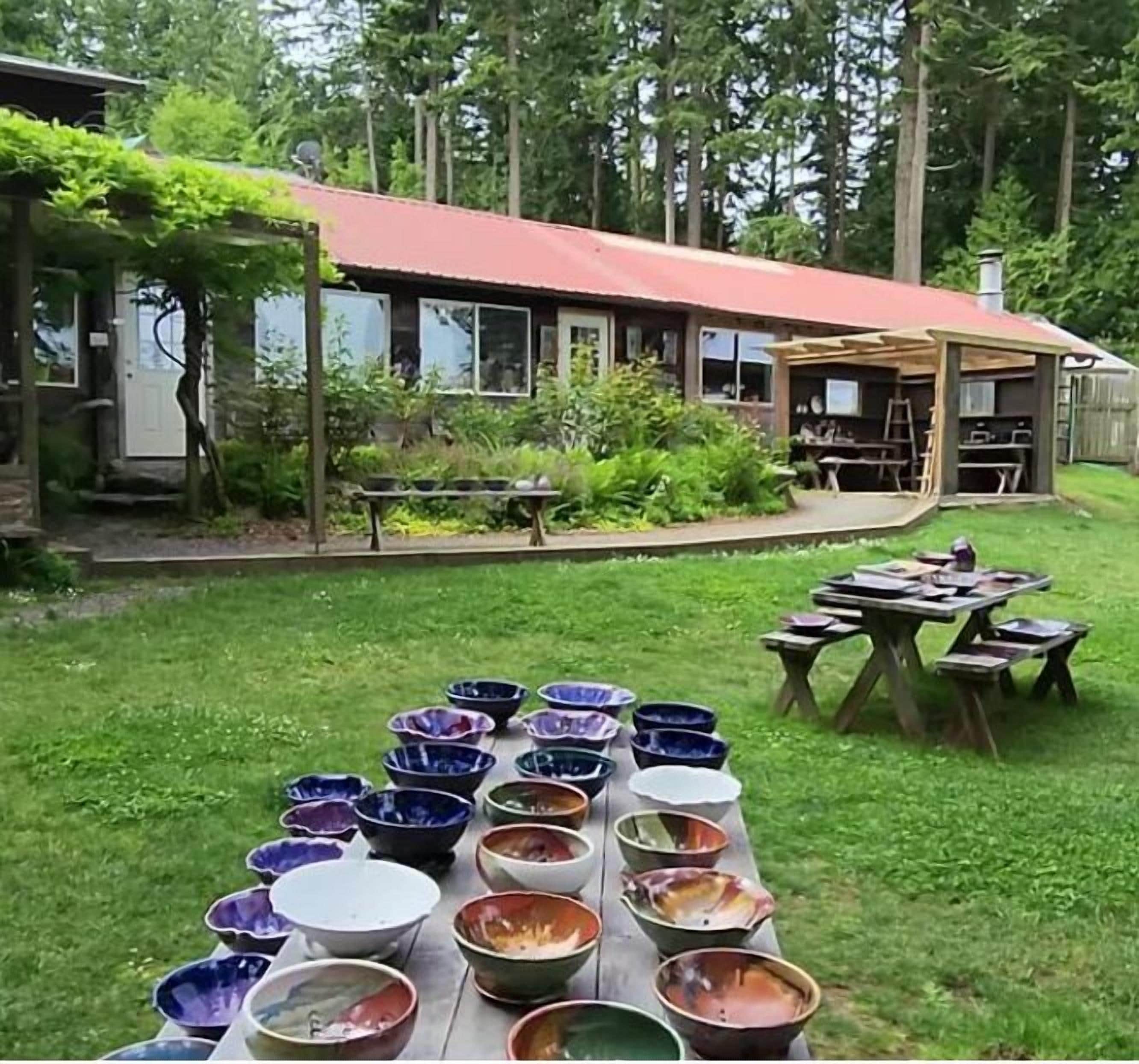A backyard with a table displaying various bowls.
