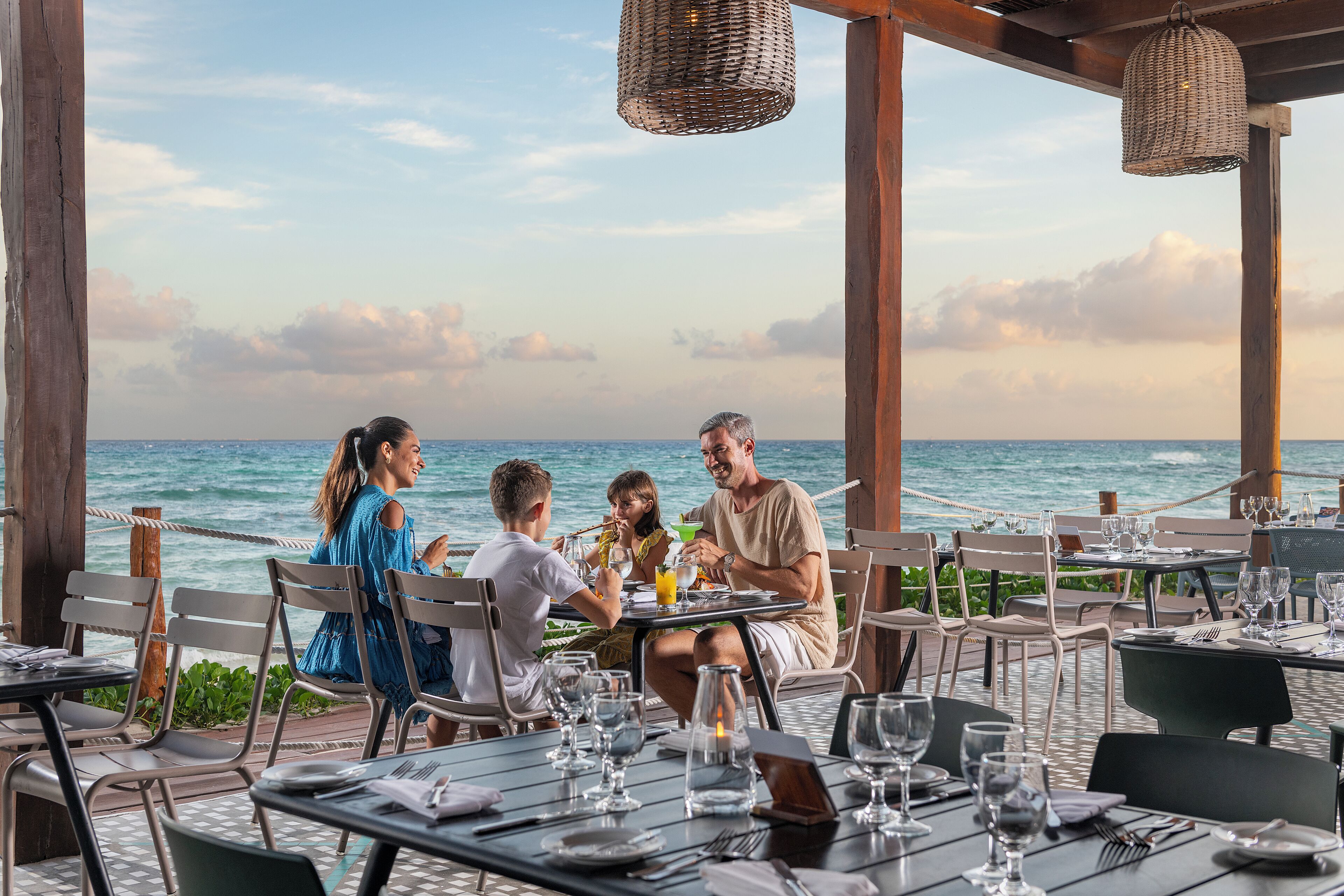 Een restaurant aan zee, met gedekte tafels met uitzicht op de oceaan.