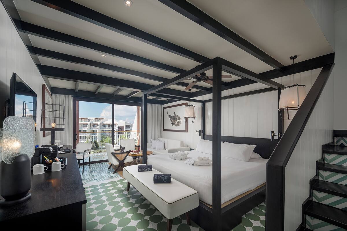 Camera d'albergo moderna con un ampio letto, una scrivania e un balcone con vista.