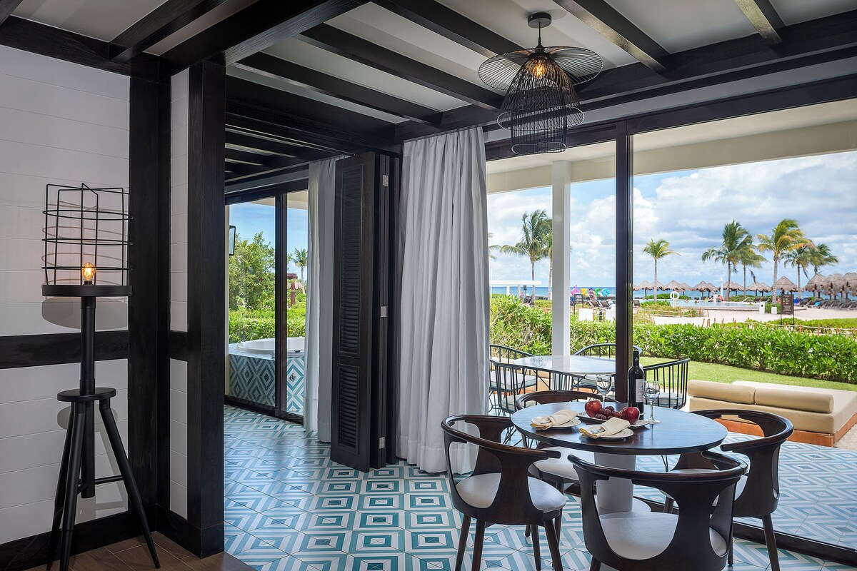 A dining area with a view of palm trees and a pool.