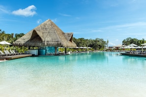 A clear blue pool with lounge chairs and a thatched-roof structure. - El Beso Adults Only at Ocean Riviera Paradise - All Inclusive (Playa del Carmen)