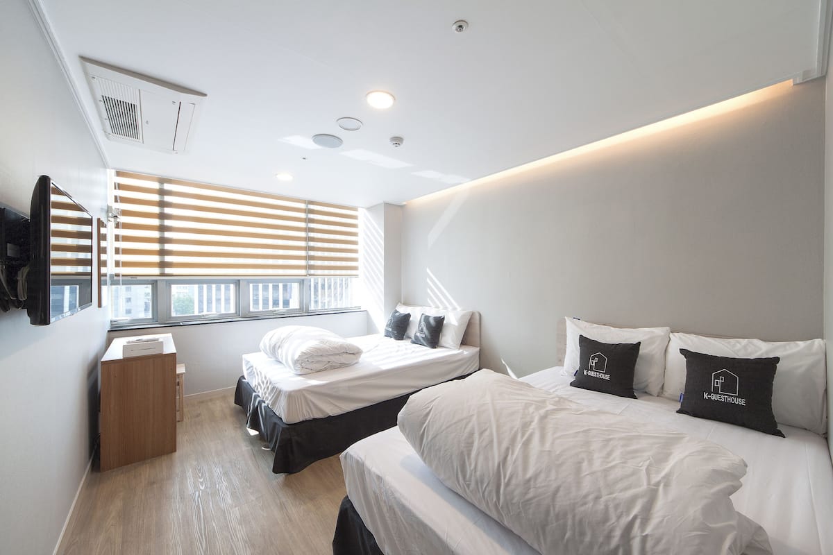 Een moderne hotelkamer met twee bedden, een bureau en een televisie.