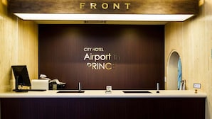 A reception desk at City Hotel Airport in PRINCE with a wooden backdrop and a sign above it. - City Hotel Airport in Prince (Izumisano)