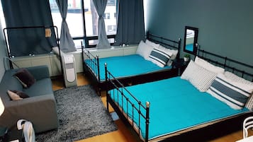 A room with two beds, a sofa, a small table, and a chair.