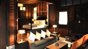 A cozy hotel room with a bed, a sofa, and a TV.