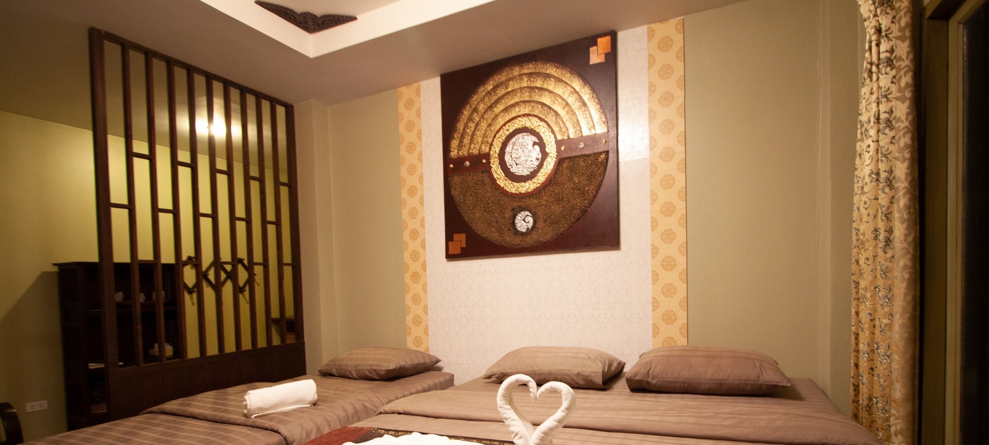 Ein Hotelzimmer mit einem Bett, einer Wanddekoration und einem Holztrennfeld.