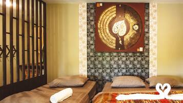 Quarto de hotel com duas camas, um objeto decorativo na parede e cortina estampada.
