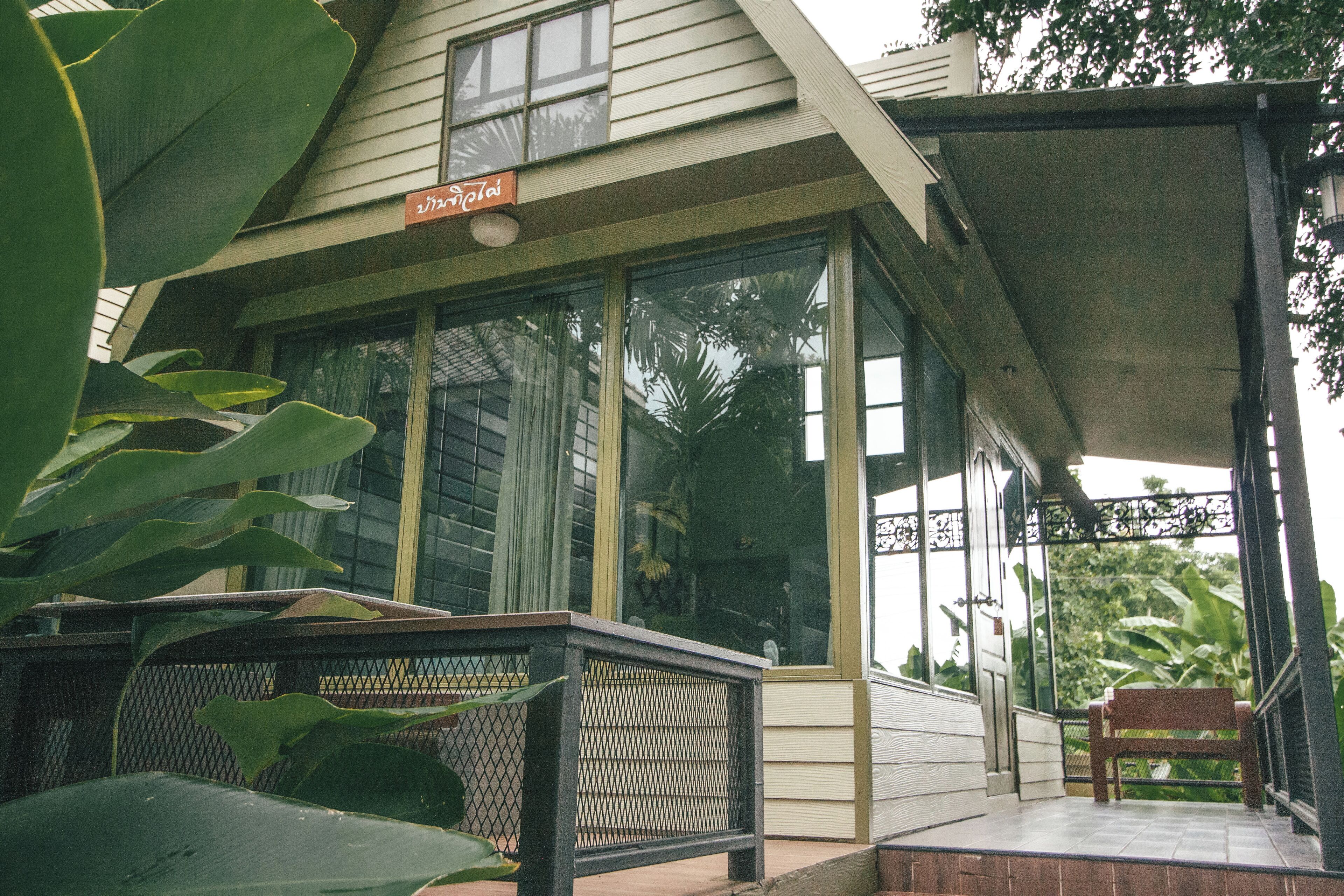 A house with a covered porch, large windows, and a sign that reads "Jardim."