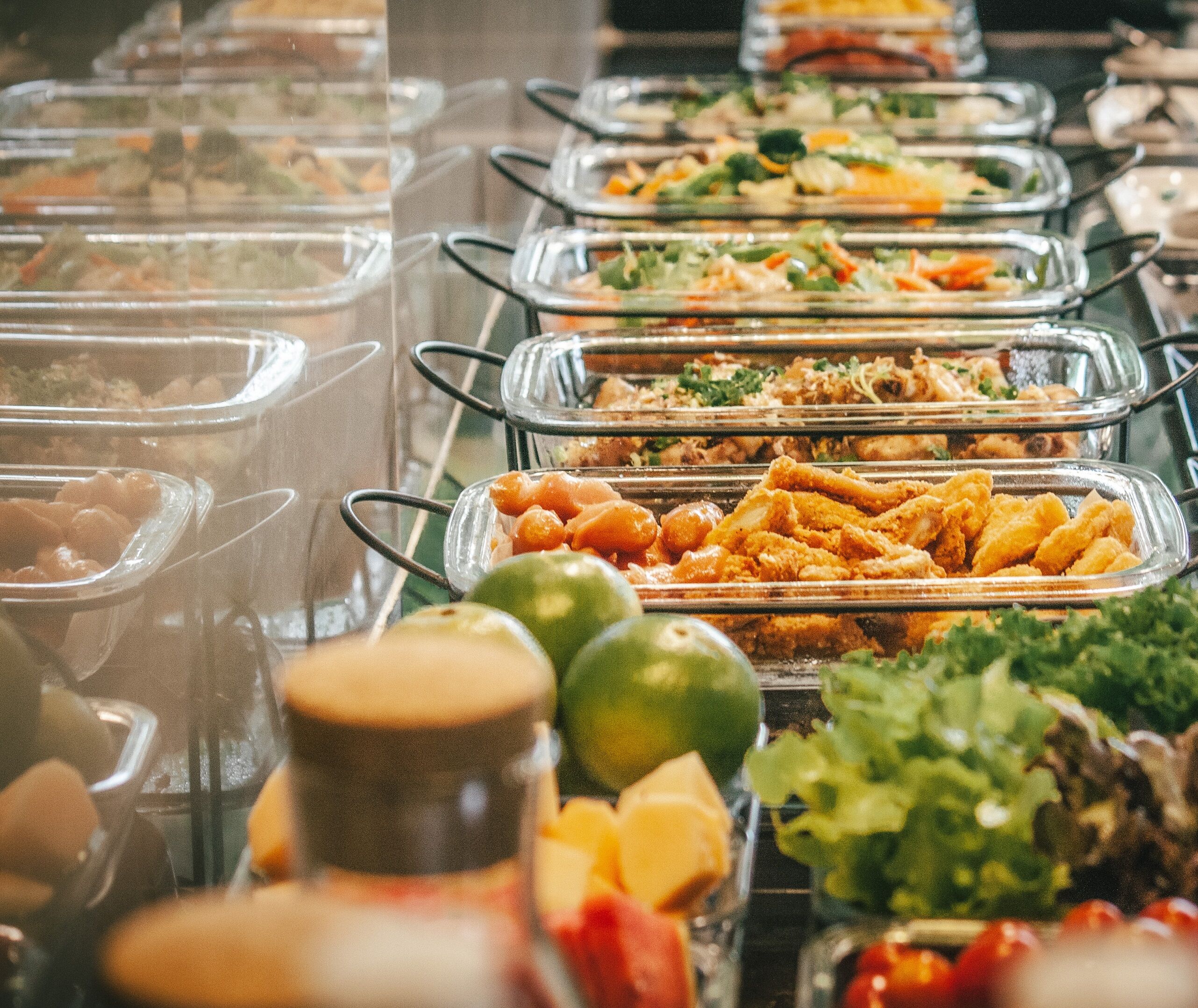 A buffet with various food items in glass containers.
