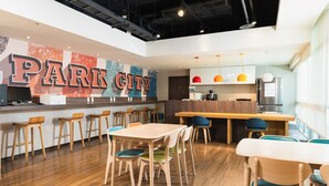 A modern restaurant with a bar area, wooden tables and chairs, and a large 'PARK CITY' sign on the wall. - Park City Inn & Hostel - Yonghe Taipei (New Taipei City)