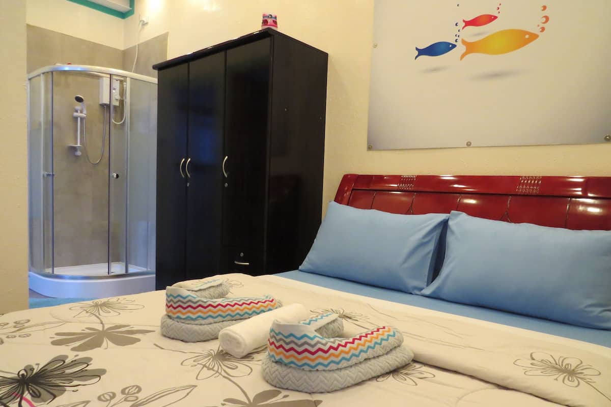 Un dormitorio con cama, armario, ducha y un adorno en la pared.