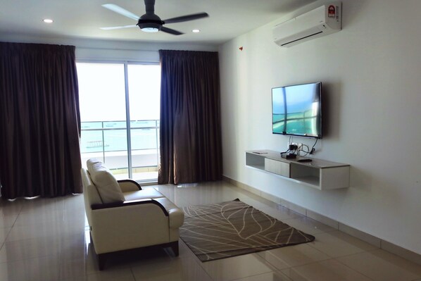 Suite, 3 chambres, balcon, vue ville | Coin séjour | Télévision LCD