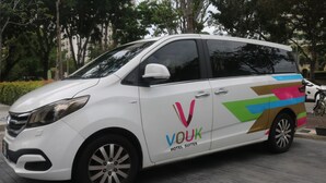 A white van with the logo "VOUK HOTEL SUITES" on its side. - Vouk Suites At Mansion One (George Town)