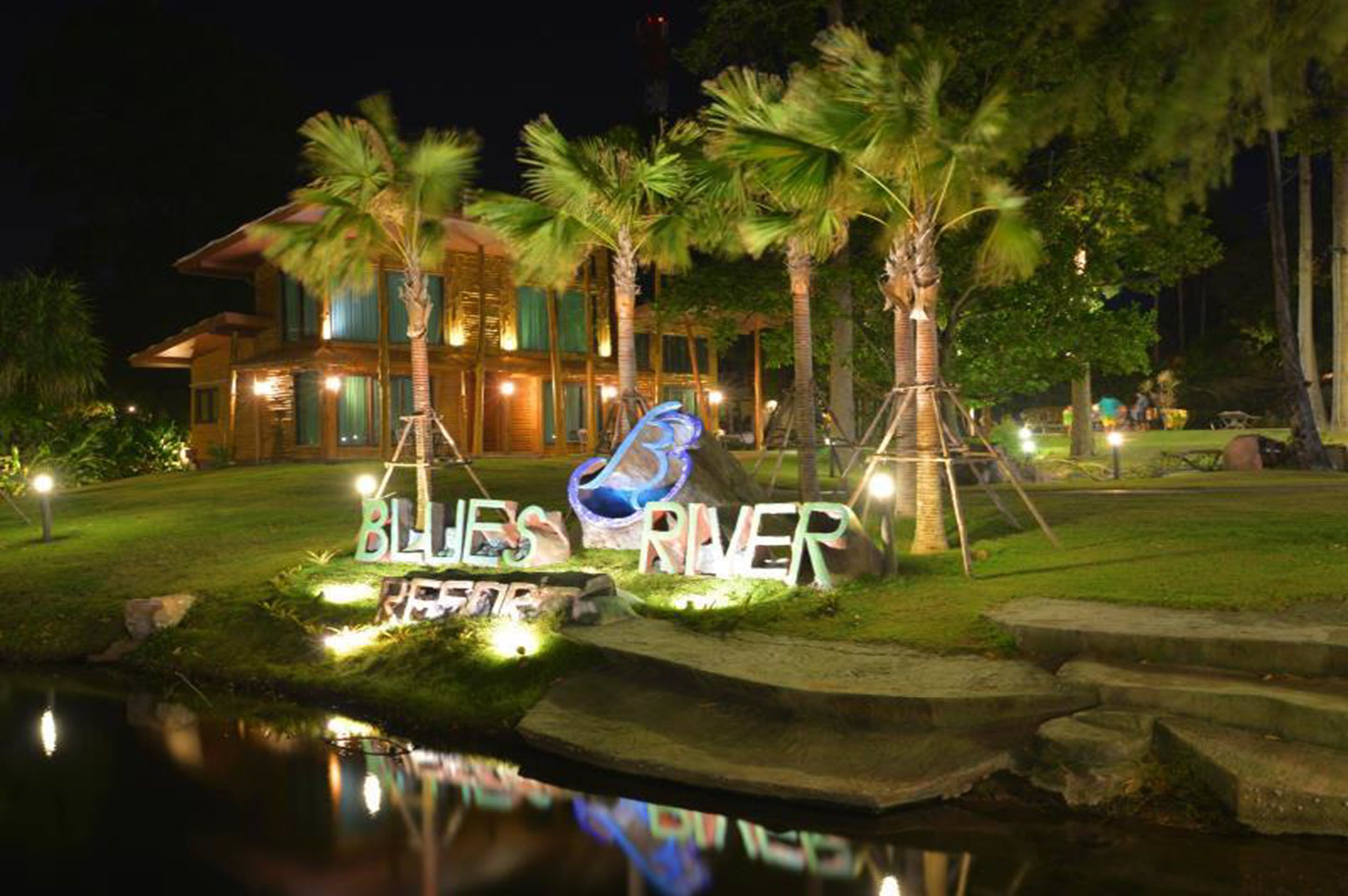 Une entrée d’hôtel bien éclairée, avec une enseigne indiquant « Blues River ».