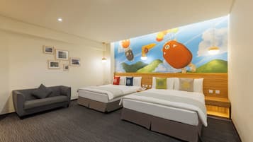 A hotel room with two beds, a sofa, and a mural of balloons and clouds on the wall.