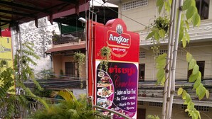 A signboard for Angkor with amenities listed, including food and laundry services.