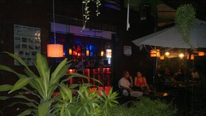 An outdoor seating area with potted plants, tables, and chairs.