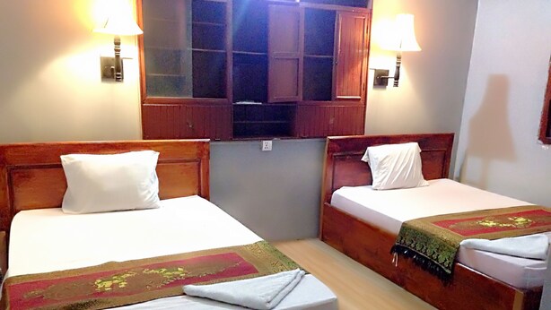 Two single beds with wooden headboards, white linens, and decorative bedspreads.