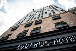 En hög byggnad med en skylt där det står ”AQUARIUS HOTEL” längst ner.