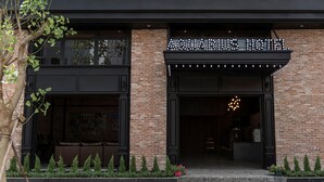 The exterior of the Aquarius Hotel with a brick facade, black trim, and a sign above the entrance. - Aquarius Hotel & Urban Resort Phnom Penh (Phnom Penh)