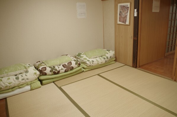 A room with tatami mats, a wooden door, and a wall with a framed picture. - Kyoto Villa Sound (Kyoto)