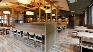 Un amplio comedor con altos vigas de madera e iluminación colgante, con diversas opciones de asientos y un diseño moderno.