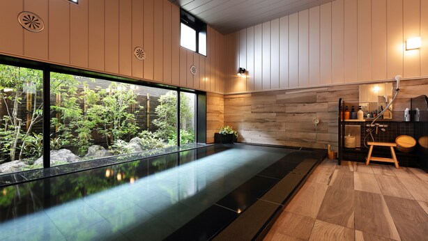 Un baño moderno con un ventanal grande, paneles de madera y un banco de madera.