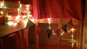 A cozy room with a bunk bed, a wooden desk, and string lights. - SunCheon Guest House ChuChun - Hostel (Suncheon)