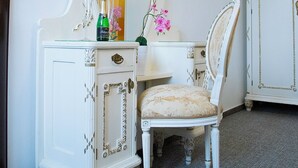 A white vanity with a mirror, a chair, and a bottle of champagne. - Old Prague House (Prague)