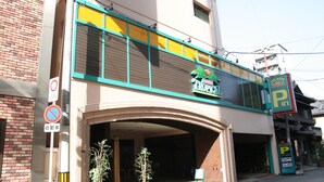 A building with a sign for 'Tropical Paradise' and a parking sign. - Hotel TROPICAL OSAKA - Adults Only (Osaka)