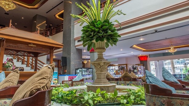 A lobby with a central fountain, seating areas, and a staircase. - KP Grand Hotel Chanthaburi (Chanthaburi)