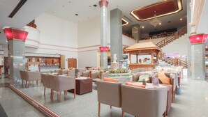A spacious lobby with multiple seating areas, a reception desk, and a staircase leading to an upper level. - KP Grand Hotel Chanthaburi (Chanthaburi)