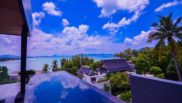 A resort with a pool overlooking a beach and ocean, traditional architecture, and lush greenery. - AQUA Villas Rawai (Rawai)
