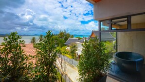 A modern building with large windows overlooking a coastal area. - AQUA Villas Rawai (Rawai)
