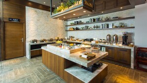 Una cocina moderna con una isla central, armarios de madera y salpicadero de piedra.