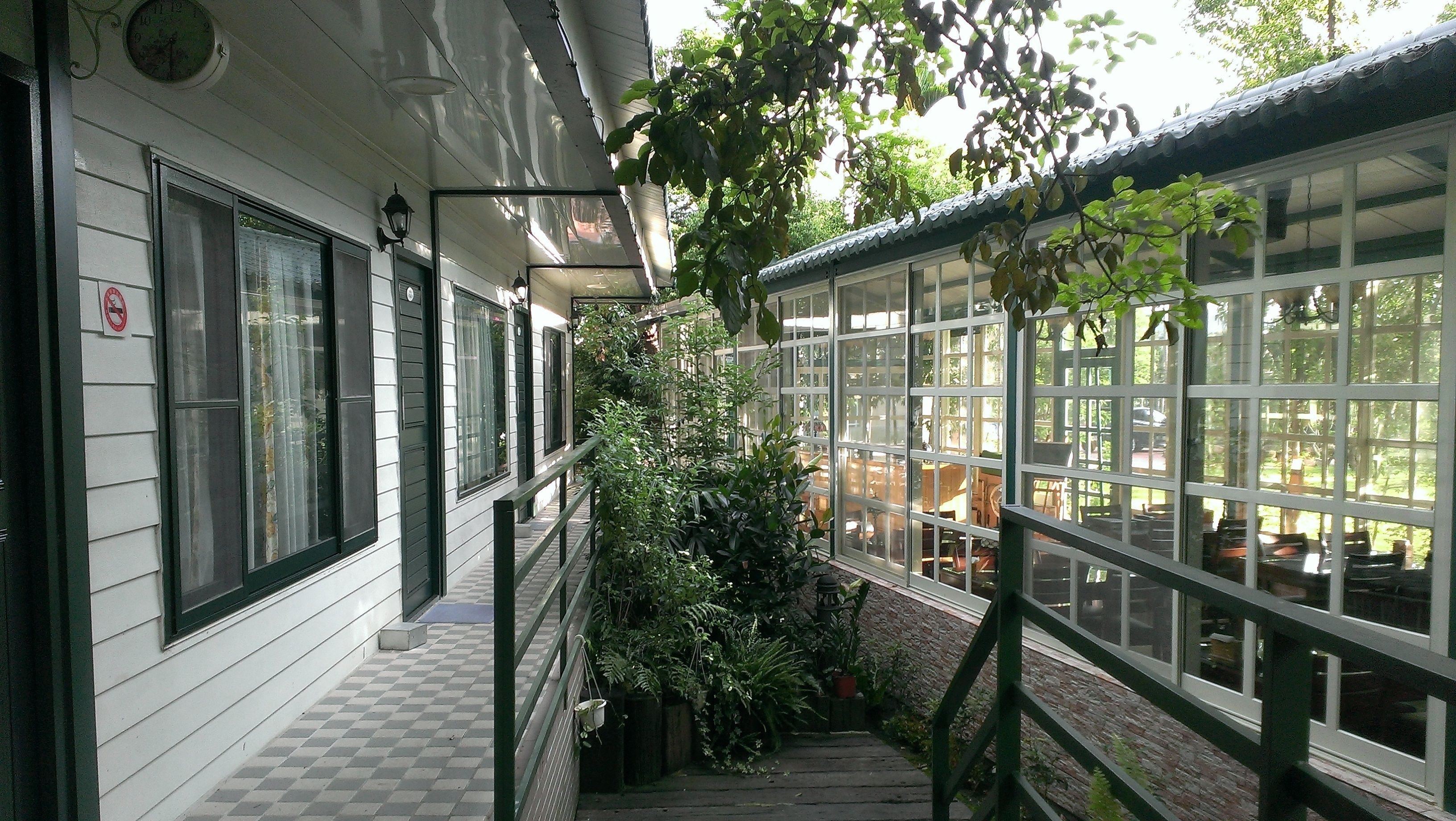 A covered outdoor area with a checkered floor, a staircase, and a railing.