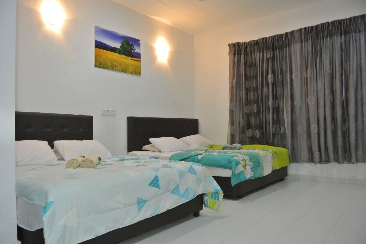 A hotel room with two beds, a painting on the wall, and a curtain.