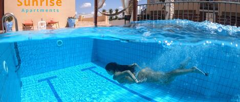 Piscine extérieure, parasols, chaises longues
