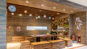A modern interior with a wooden reception desk, benches, and a clock. - Hualien Toong Mao Resort (Ji'an)