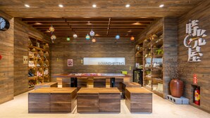 A modern interior with wooden panel walls, a central table with seating, and decorative hanging lights. - Hualien Toong Mao Resort (Ji'an)