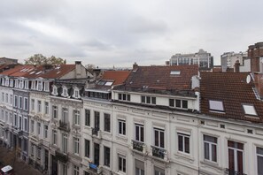 A row of historic buildings with classic European architecture, featuring uniform window designs and balconies. - Apartments Résidence Louise (Brussels)