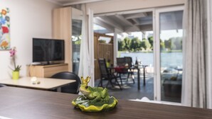 Una habitación moderna con una mesa de madera, un televisor y una figurita decorativa de una rana.